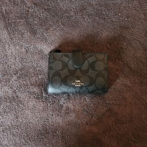 Coach Meduim Black Wallet with gold emblem.